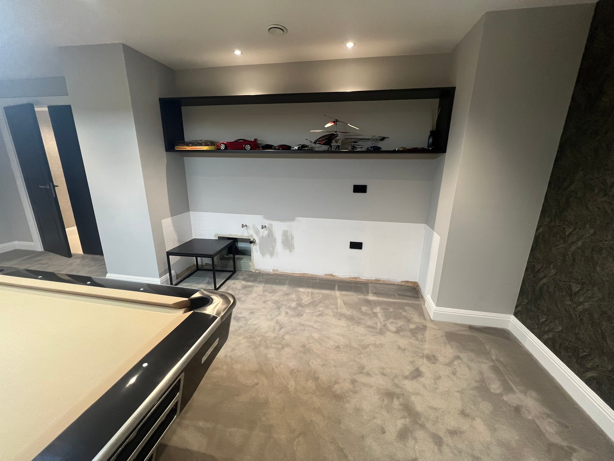 Unfinished alcove in a private games room before the installation of bespoke home bar cabinetry.