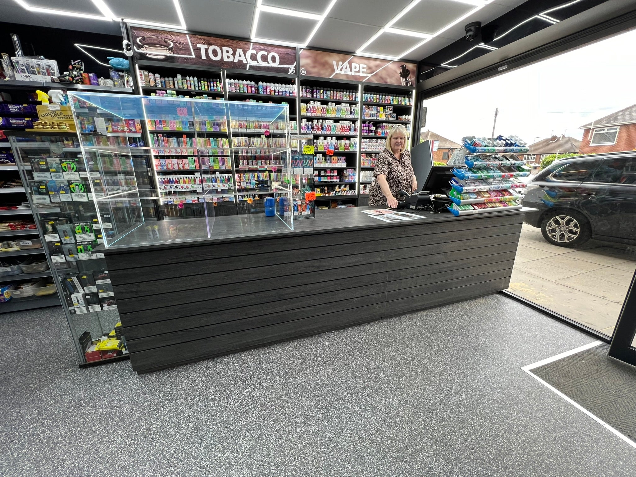 Completed Outwood Express retail counter with lockable cabinetry, illuminated acrylic display case and custom vape gantry.