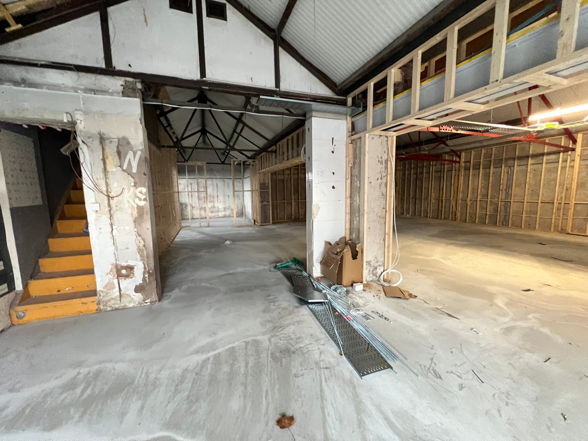 YOH Burger commercial unit during construction with exposed wall framing and an unfinished open-plan interior.