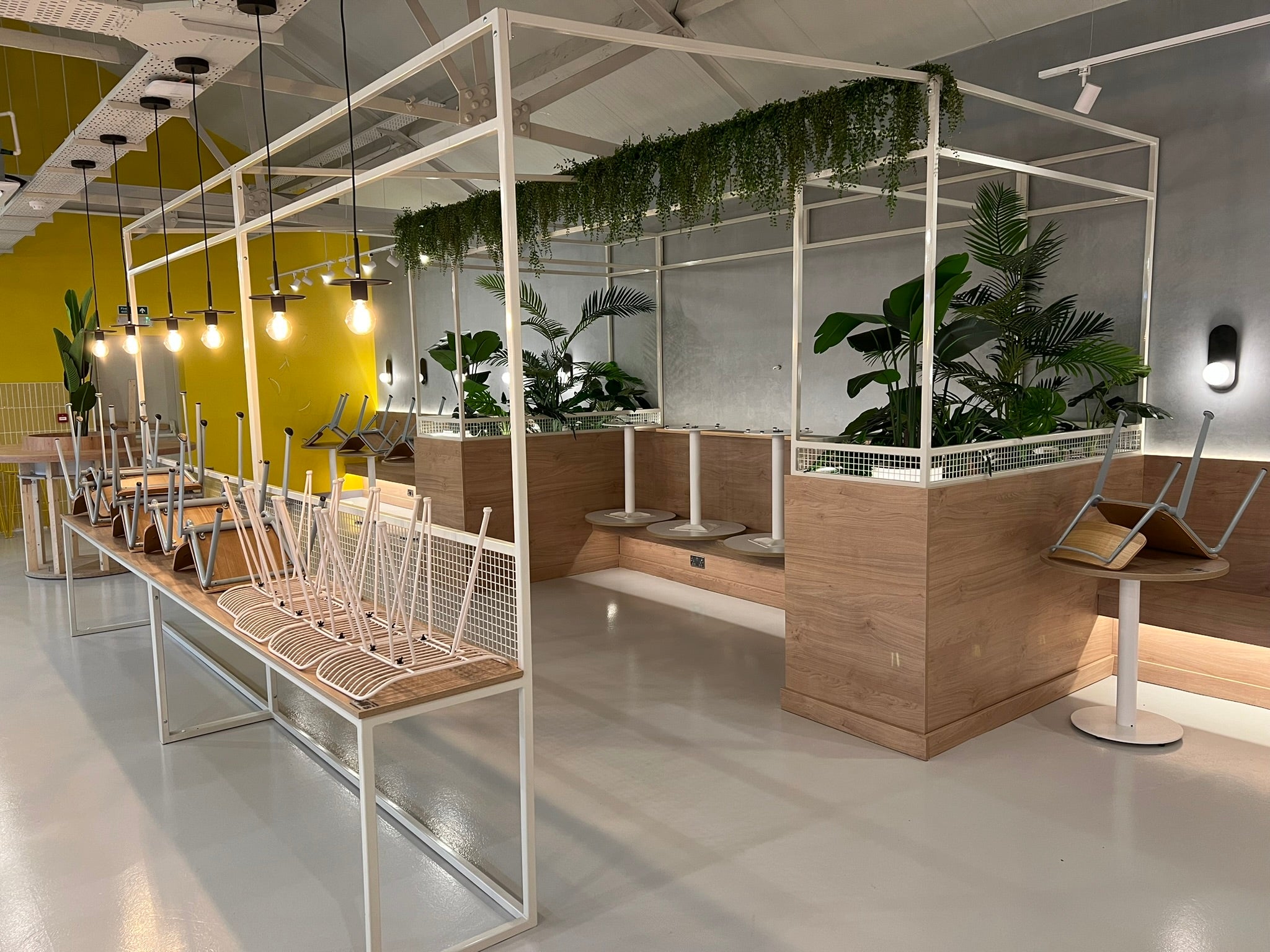 Completed YOH Burger dining area and open commercial kitchen with branded yellow and grey finishes.