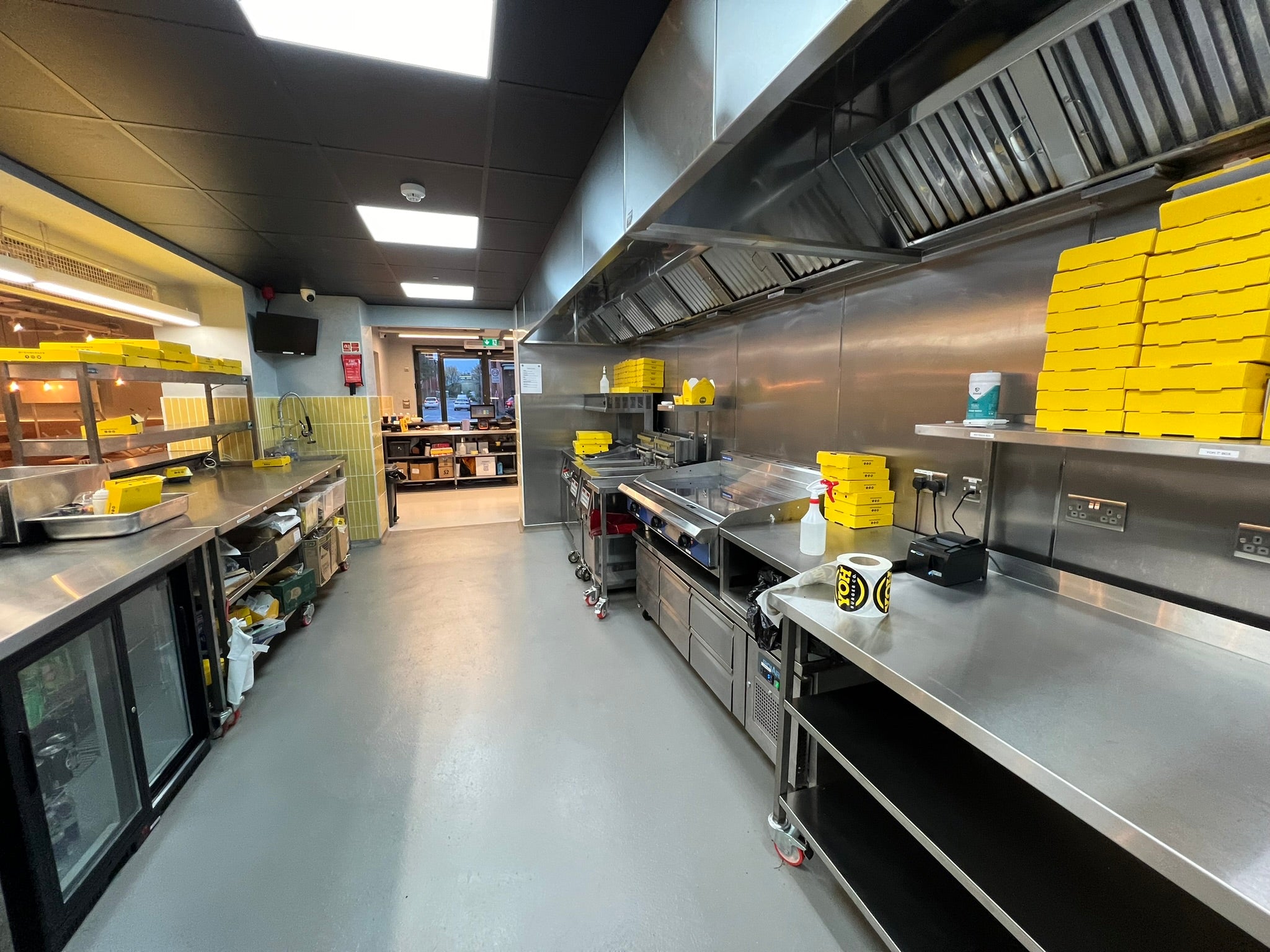 Fully equipped YOH Burger commercial kitchen with stainless steel preparation counters, cooking equipment and refrigerated storage.