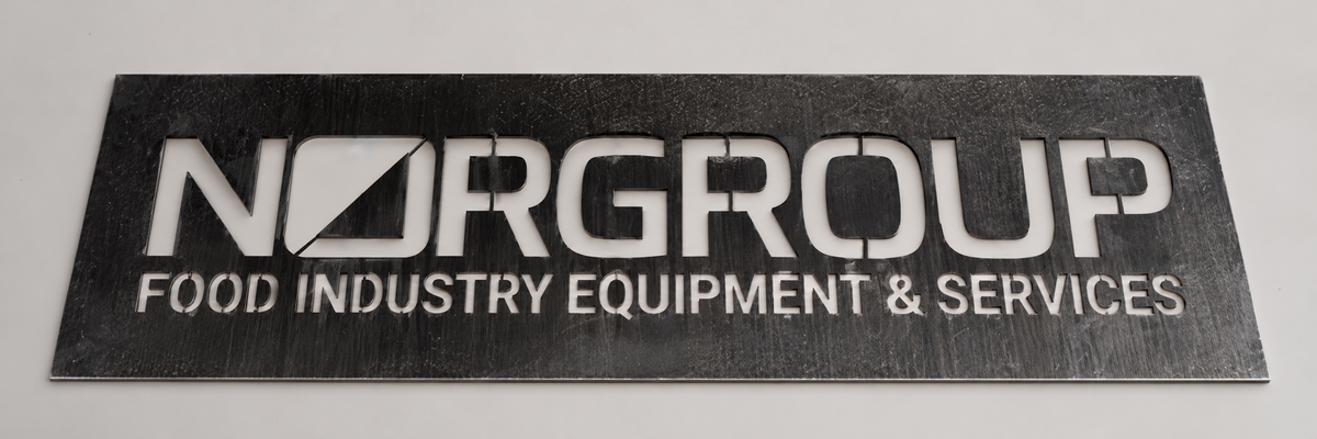 Norgroup lettering cut into an aluminium stencil.